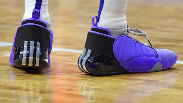 View of purple and black adidas shoes.